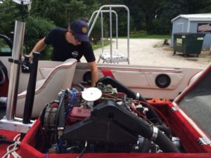 A picture of a man working on a boat engine