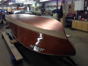 An upside down boat being worked on in the shop